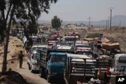 FILE - People flee violence in Daraa, southern Syria, in this June 28, 2018 photo provided by Nabaa Media, a Syrian opposition media outlet.