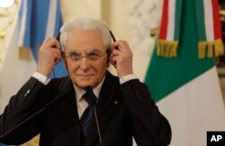 FILE - Italy's President Sergio Mattarella puts on headphone during a meeting with Argentina's President Mauricio Macri in Buenos Aires, Argentina, May 8, 2017.