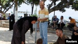 FILE - Members of a Syrian refugees family, who fled the violence in Syria, are seen at a garden in Port Said Square in Algiers, July 30, 2012. 