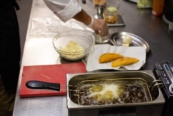 El chef venezolano Daniel Cadena prepara una empanada de su emprendimiento "La Qué Tal", en Barcelona, España. Foto: Cortesía.