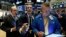 Traders Andrew Silverman, Gregory Rowe, and James Lamb, left to right work on the floor of the New York Stock Exchange, Aug. 15, 2019. 