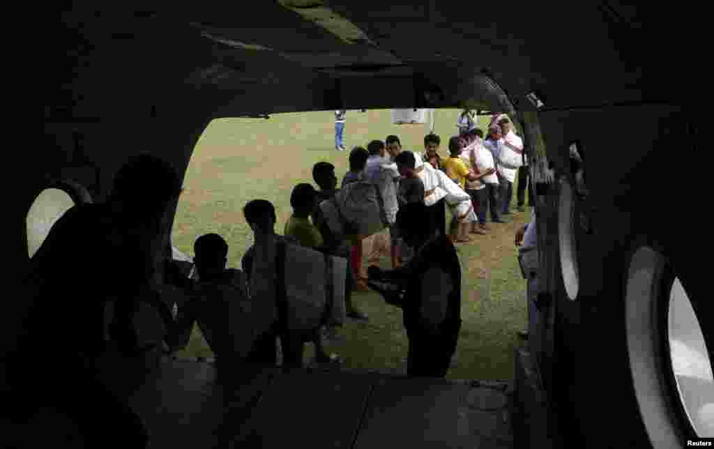 Men load emergency food supplies onto a helicopter after the April 25 earthquake in Deurali, Nepal, May 8, 2015.