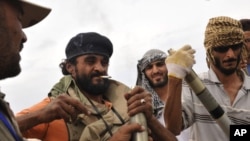 Libyan revolutionary fighters assemble missiles during an attack for the city of Sirte, Libya, October 3, 2011.