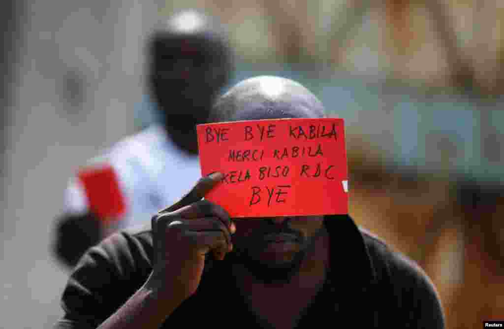 Militante da oposição empunha cartaz contra o presidente&nbsp; Joseph Kabila, hoje em Kinshasa.