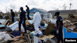 FILE PHOTO: Police officers search for the dead in the destroyed Mudd neighborhood after Hurricane Dorian hit the Abaco Islands in Marsh Harbour, Bahamas, September 10, 2019. REUTERS/Marco Bello/File Photo