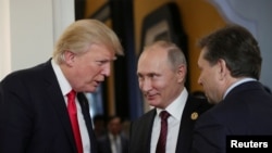 U.S. President Donald Trump and Russian President Vladimir Putin talk during a break in a session of the APEC summit in Danang, Vietnam, Nov. 11, 2017. 