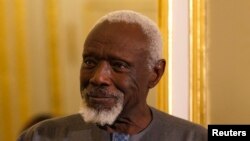 L'artiste sénégalais Ousmane Sow écoute le président français lors d'une cérémonie en son honneur à Paris, le 11 décembre 2013.