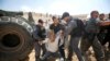 Beberapa polisi Israel menahan seorang pria Palestina saat memprotes rencana Israel untuk menghancurkan desa Badui Khan al-Ahmar, di Tepi Barat, wilayah Palestina yang diduduki Israel.