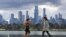 People exercise in front the city skyline in Melbourne on August 29, 2021, as authorites announced the extension of an ongoing coronavirus lockdown in Australia's second-biggest city. (Photo by William WEST / AFP)