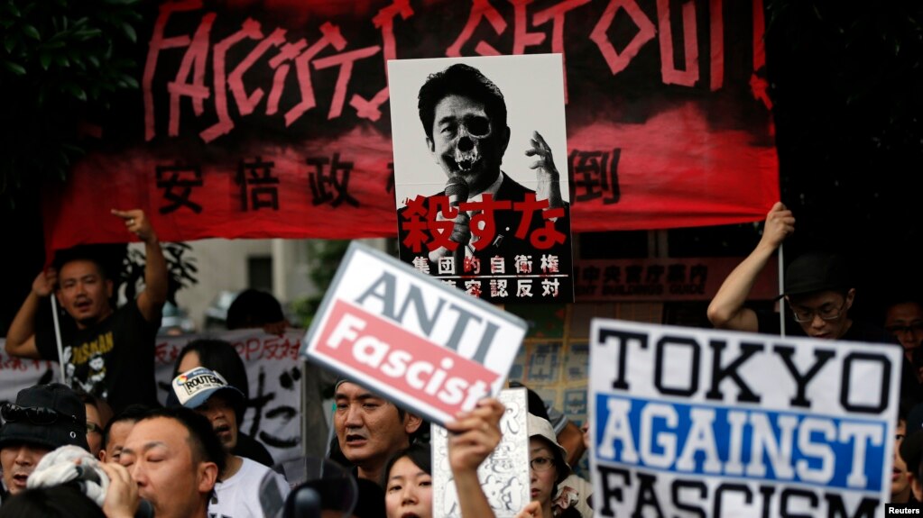 Protesters holding placards shout slogans at a rally against Japan's Prime Minister Shinzo Abe's push to expand Japan's military role in front of Abe's official residence in Tokyo, June 30, 2014.