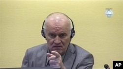 In this image made from television, former Bosnian Serb Gen. Ratko Mladic gestures during his initial appearance at the U.N.'s Yugoslav war crimes tribunal in The Hague, Netherlands, June 3, 2011