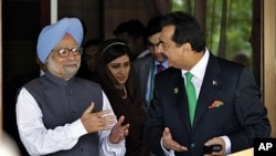 Pakistani Prime Minister Yousuf Raza Gilani, right, and Indian Prime Minister Manmohan Singh gesture after their meeting on the sidelines of the South Asian Association for Regional Cooperation (SAARC) summit in Addu, Maldives, November 10, 2011.