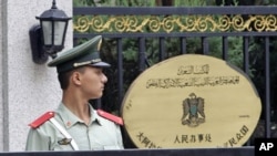 A paramilitary policeman stands guard at the entrance of the Libyan embassy in Beijing, August 23, 2011