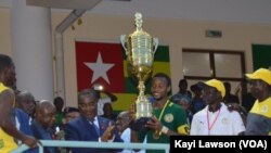 Le Premier ministre togolais Komi Sélom Klassou remet le trophée de la 7ème édition du tournoi de l'intégration de l 'UEMOA au capitaine du Sénégal, Togo, 3 décembre 2016. VOA/Kayi Lawson.