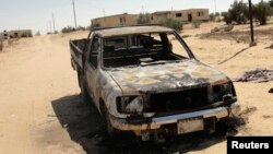 Sebuah mobil hancur terbakar pasca serangan militan di wilayah Sheikh Zuweid, dekat kota El-Arish di Jazirah Sinai, Mesir (10/9). Sedikitnya tiga orang tentara dilaporkan tewas dalam serangan militan di markas besar intelijen militer di kota Rafah (11/9).