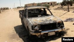 The wreckage of a burnt car is seen after assaults on militant targets by the Egyptian Army, in a village on the outskirts of Sheikh Zuweid, near the city of El-Arish in Egypt's Sinai peninsula, Sept. 10, 2013. 