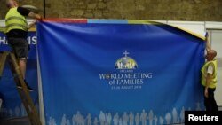 Workmen put the finishing touches to signage at at the Papal Congress at the World Meeting of Families in Dublin, Ireland, Aug. 21, 2018.