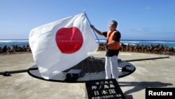 日本东京都知事石原慎太郎在冲之鸟展示日本国旗（2005年5月20日）