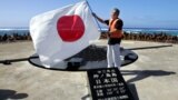 日本东京都知事石原慎太郎在冲之鸟展示日本国旗(2005年5月20日)