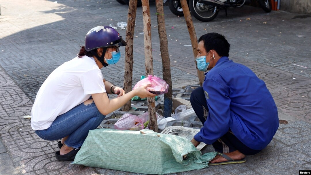 Một người vô gia cư nhận đồ ăn từ một tình nguyện viên.