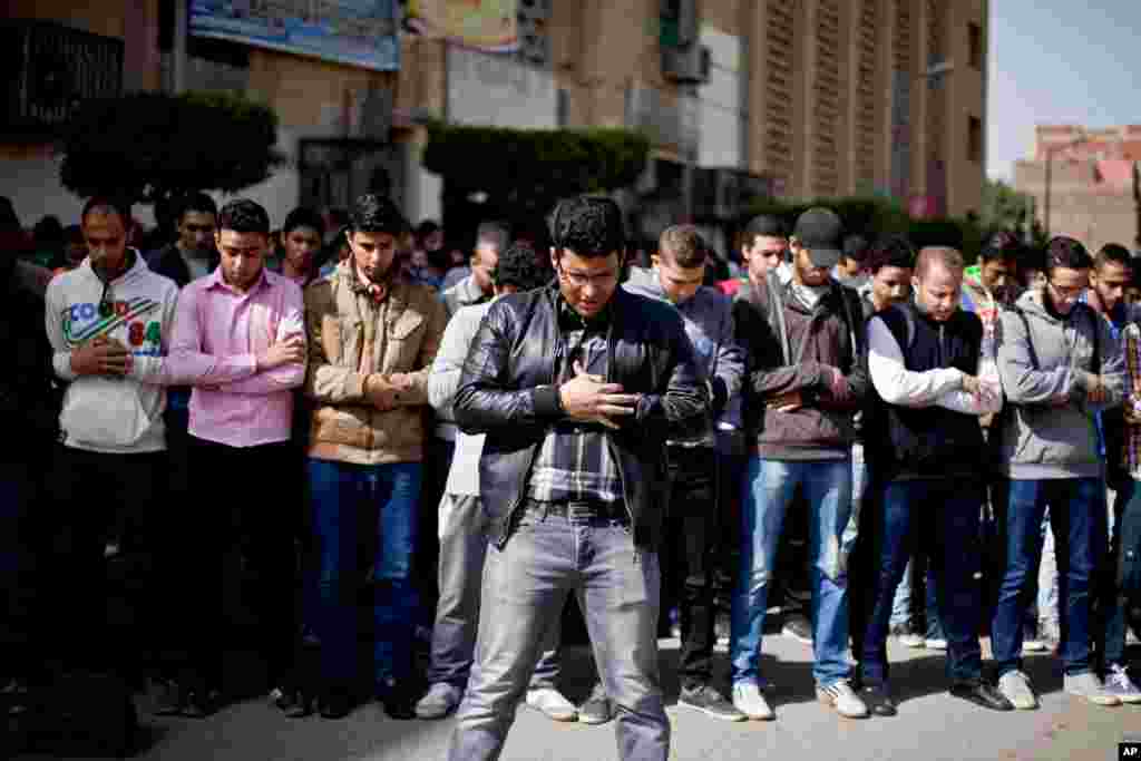 Egyptian students pray for people who were killed on Sunday during a riot, outside the Air Defense Stadium, at Cairo University in Egypt, Feb. 9, 2015.