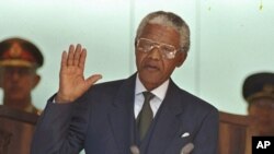 FILE - Nelson Mandela, left, takes the oath of office in Pretoria, South Africa, to become the country's first black President.