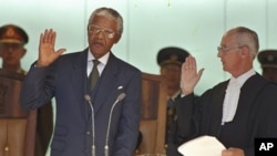 In this May 10, 1994, file photo, Nelson Mandela, left, takes the oath of office in Pretoria, South Africa, to become the country's first black President.