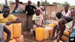 Women fill empty containers with water in the Nagrin neigborhood of Ouagadougou, Burkina Faso. Water trickles out of the faucet sometimes around 2 a.m., then by dawn the taps run empty at Dramane Drabo’s laundry business on May 11, 2016.