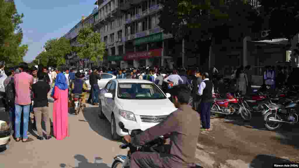 People gather outside after a strong earthquake shook northern Afghanistan and Pakistan.
