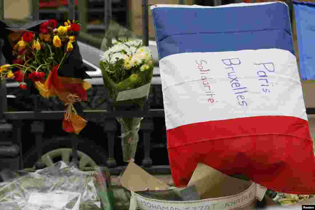 A French flag with the message 'Paris Brussels Solidarity' is displayed next to flowers with the colors of the Belgium flag in front of the Belgium embassy in Paris, France, March 23, 2016 in tribute to the victims of Tuesday's bomb attacks in Brussels. 