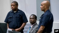 Dominic Ongwen, center, a senior commander in the Lord's Resistance Army, sits in the court room of the International Court in The Hague, Netherlands, Dec. 6, 2016.