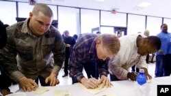 FILE - Job seekers fill out their forms at an employment expo in Jackson, Miss., March 17, 2009. 