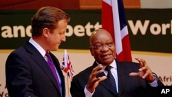 British Prime Minister David Cameron talks with South African President Jacob Zuma (R) as they attend a media conference in Pretoria in this handout picture, July 18, 2011