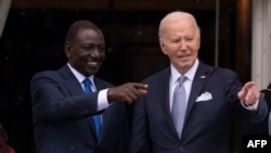 FILE—Kenyan President William Ruto (L) and US President Joe Biden point to the crowd during an official arrival ceremony on the South Lawn of the White House in Washington, DC, on May 23, 2024.