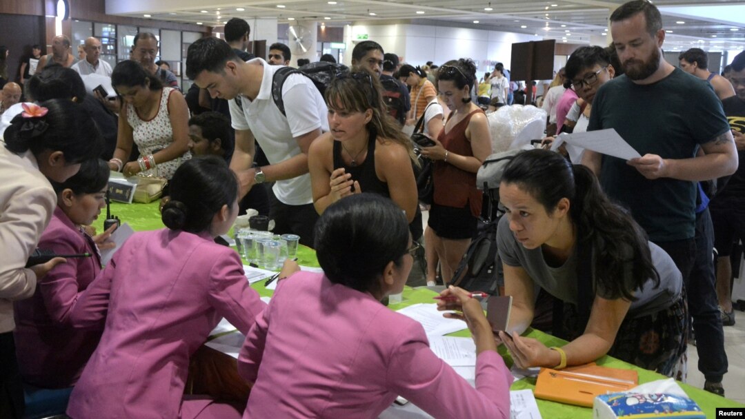 Para penumpang yang terlantar sedang menanyakan kepada petugas mengenai penerbangan mereka, setelah Bandara Internasional Ngurah Rai ditutup sementara akibat letusan Gunung Agung, Denpasar, 27 November 2017. (Antara Foto/Fikri Yusuf/ via REUTERS)