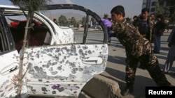 A member of Afghan security force investigates a vehicle damaged by a remote-controlled bomb, at the site of an incident in Kabul, Oct. 14, 2014. 