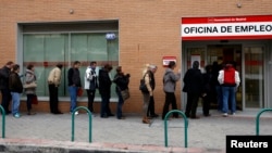 People wait in line to enter a government-run employment office in Madrid March 4, 2013.