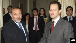 Israel's Foreign Minister Avigdor Lieberman, left, and his Greek counterpart Dimitris Droutsas shake hands in Athens, Greece, 12 Jan 2011