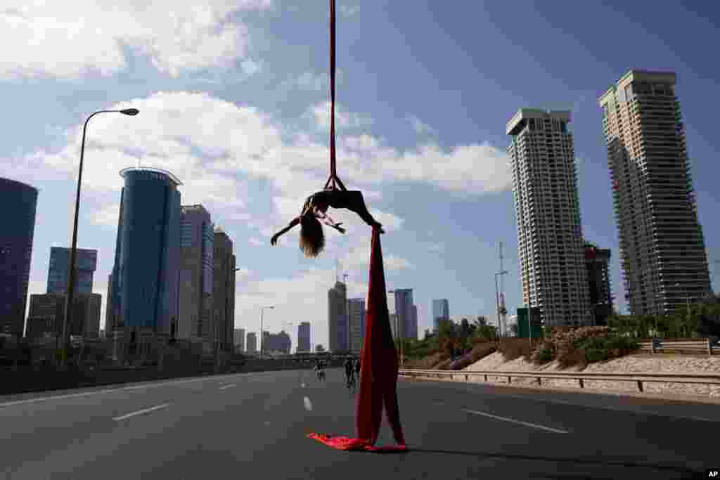 Israeli acrobat Tel Karassin performs on a car-free highway, during the Jewish holiday of Yom Kippur in Tel Aviv.