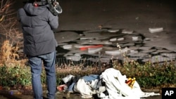 A television cameraman films a pond in New York's Central Park after several teenagers were rescued when they fell through the ice into the pond , Feb. 20, 2017.