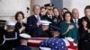 Former President George W. Bush, Laura Bush, left, and other family members watch as the flag-draped casket of former President George H.W. Bush is carried by a joint services military honor guard to lie in state in the rotunda of the U.S. Capitol, Dec. 3