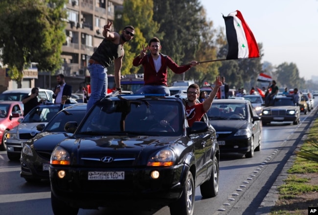 Người ủng hộ chính phủ Syria phất cờ và hô khẩu hiệu chống Tổng thống Mỹ Donald Trump trong những cuộc biểu tình sau các cuộc không kích.