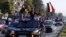 Syrian government supporters wave national flags and chant slogans against U.S. President Trump during demonstrations following a wave of U.S., British and French military strikes to punish President Bashar Assad for suspected chemical attack against civi