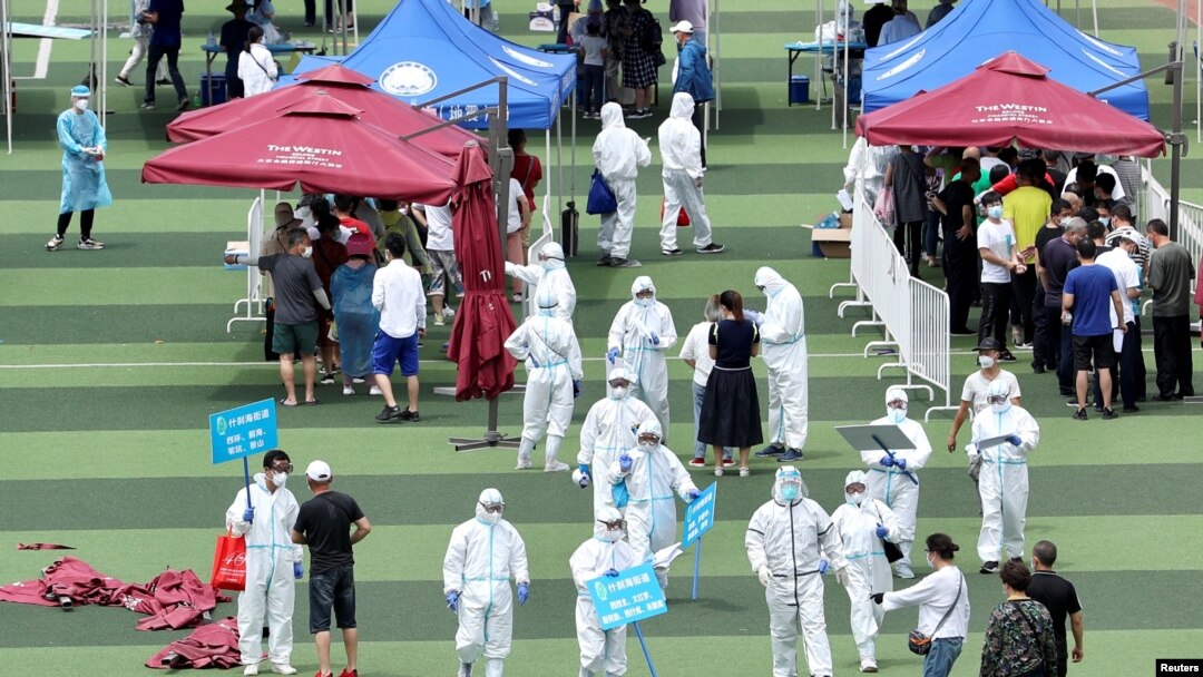 Petugas medis mengatur orang-orang untuk persiapan tes virus corona di sebuah gelanggang olahraga menyusul munculnya kasus-kasus baru Covid-19 di Beijing, China, 15 Juni 2020.
