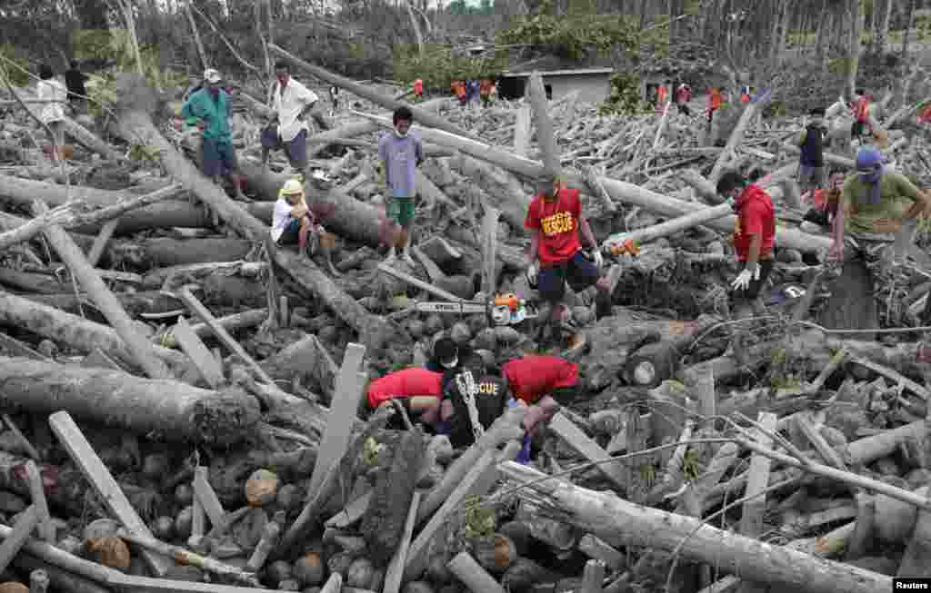 Petugas penyelamat menemukan jenazah korban topan dari puing-puing yang dibawa banjir di kota New Bataan, Compostela Valley, Filipina (7/12).