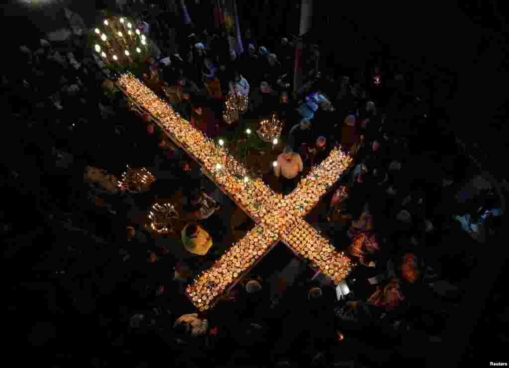 Worshipers gather around candles during a Mass to mark the day of Saint Haralampi, the Orthodox patron saint of beekeepers, in the church of the Presentation of the Blessed Virgin in Blagoevgrad, Bulgaria.