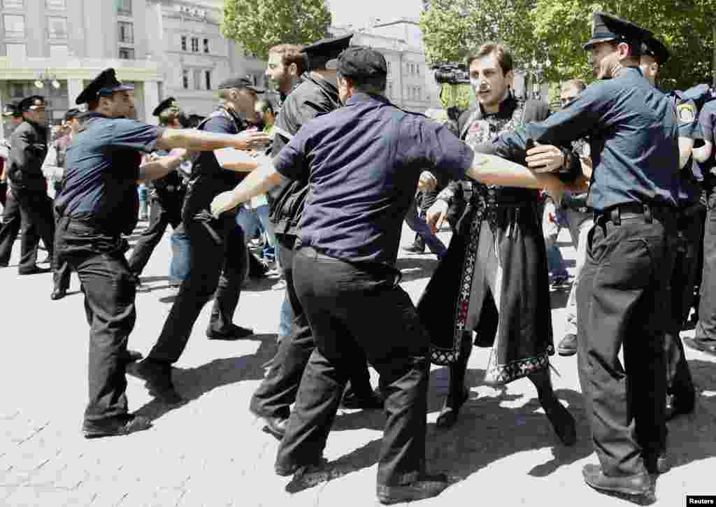 Polislər Beynəlxalq Homofobiya və Transfobiyaya Qarşı Gündə toqquşma zamanı pravoslav xristian fəalın qarşısını almağa cəhd göstərir.&nbsp; Tbilisi, 17 may, 2013. 