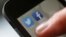 FILE - A man starts his Twitter app on a mobile device in Hanau near Frankfurt, Oct. 21, 2013.