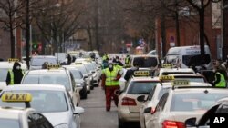 People as the arrive and departure with taxies at the COVID-19 vaccination center in the district Treptow in Berlin, Germany, Jan. 28, 2021.