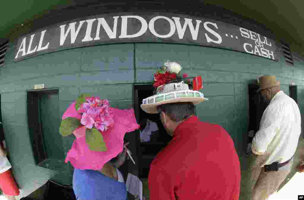 Fans make wagers before the 140th running of the Kentucky Derby horse race at Churchill Downs in Louisville, Kentucky, May 3, 2014.